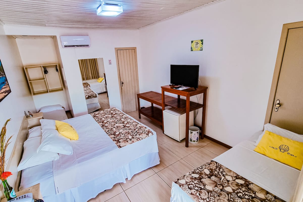 Ein Hotelzimmer mit Bett, Schreibtisch, Fernseher und einer Tür.