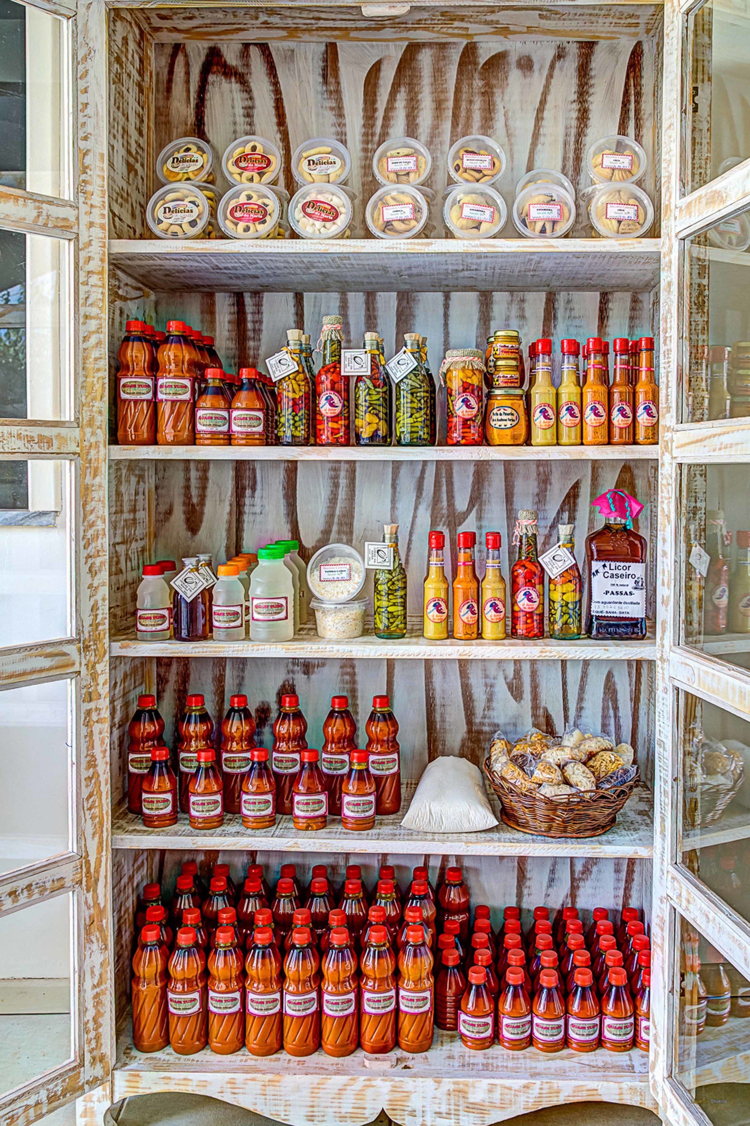 Une étagère remplie de divers condiments et sauces, notamment des bocaux de cornichons, des bouteilles de sauce piquante et des pots de moutarde.