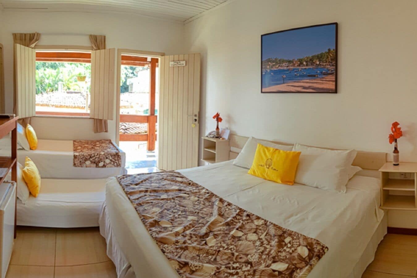 A hotel room with a bed, a sofa, a desk, and a window with curtains.