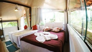 A room with a bed, two bedside tables, a ceiling fan, and a window with curtains. - Pousada Guapuruvu (Angra dos Reis)