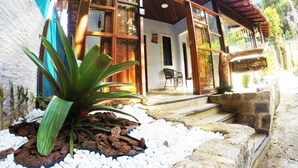 A building with a wooden exterior, large windows, and a sign that reads 'Pousada Guimarães.' - Pousada Guapuruvu (Angra dos Reis)
