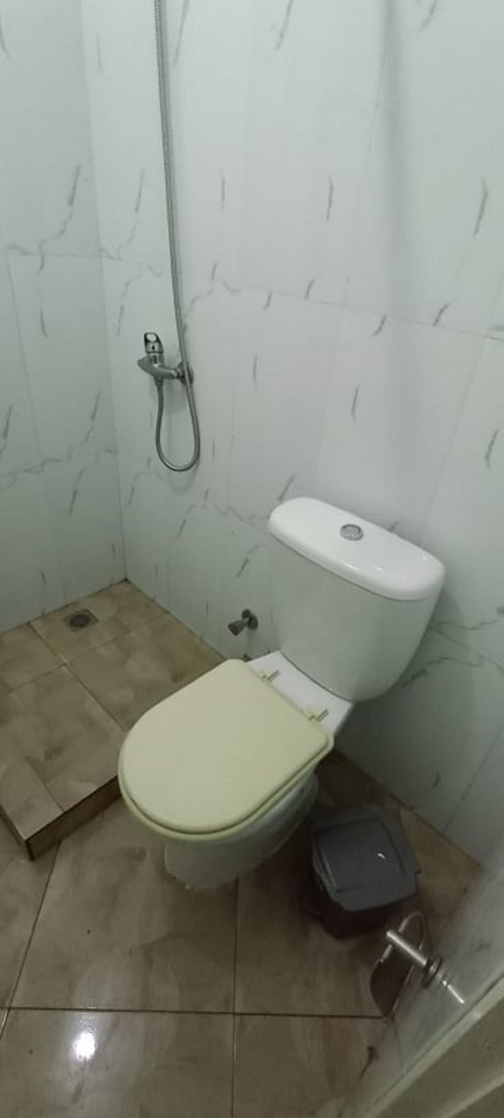 A small bathroom with a toilet, a shower, and a sink.
