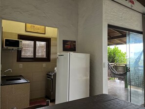 A kitchenette with a refrigerator, oven, and microwave. - Pousada Vale Verde Bungalows (Imbituba)