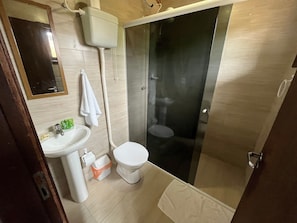 A modern bathroom with a toilet, sink, and shower. - Pousada Vale Verde Bungalows (Imbituba)