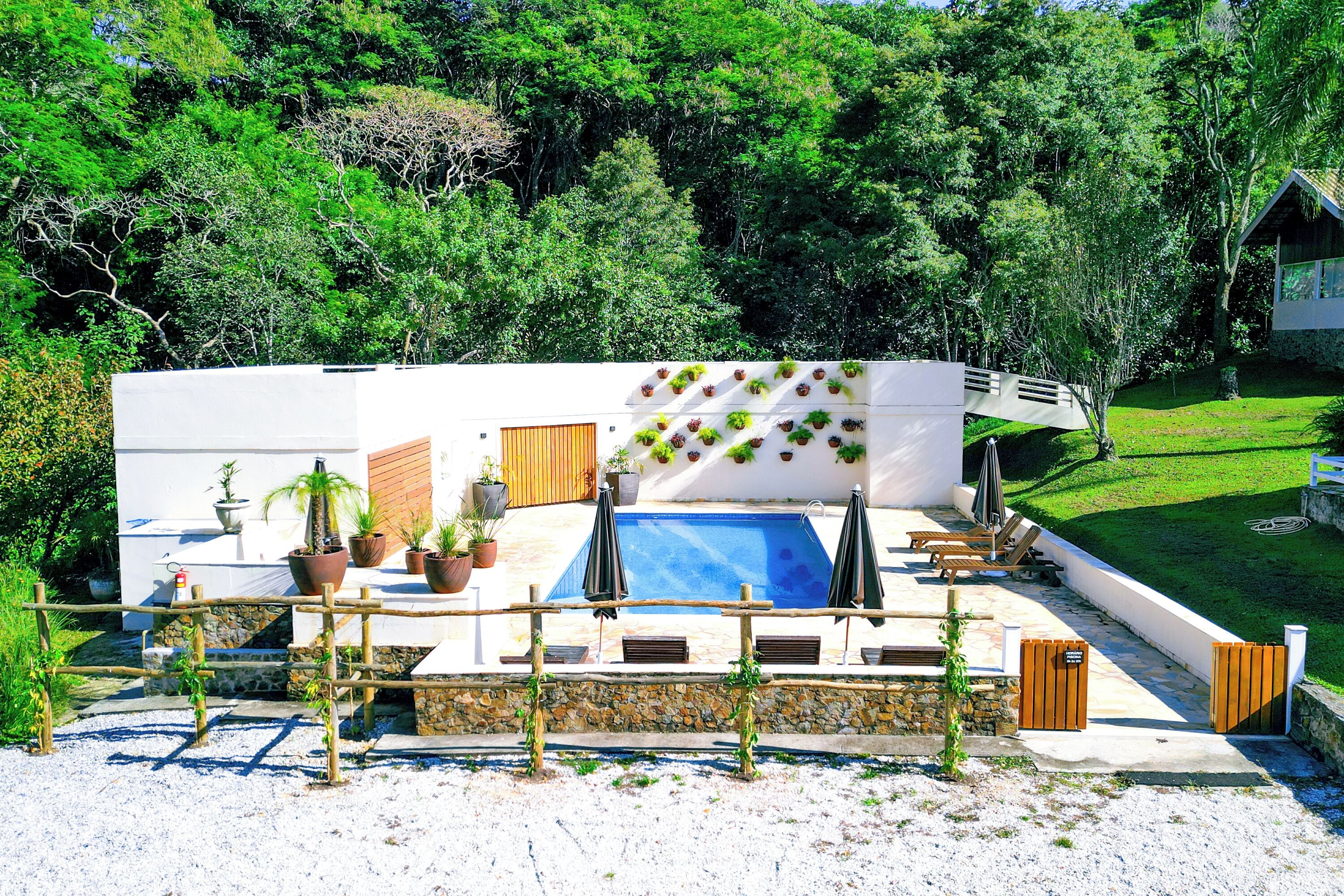 Una piscina techada, una piscina al aire libre, sombrillas