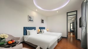 A hotel room with two beds, a sitting area with a table and chairs, and a view into the hallway. - Hanoi La Palm Boutique Hotel (Hanoi)