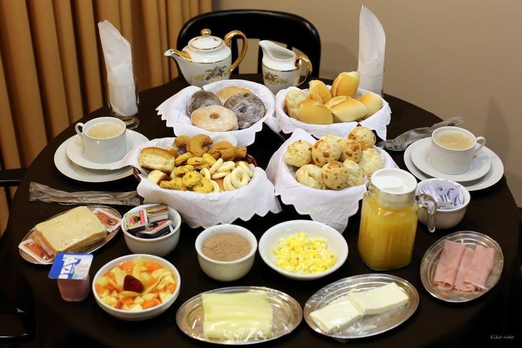 A breakfast spread with various pastries, sandwiches, and beverages on a table.