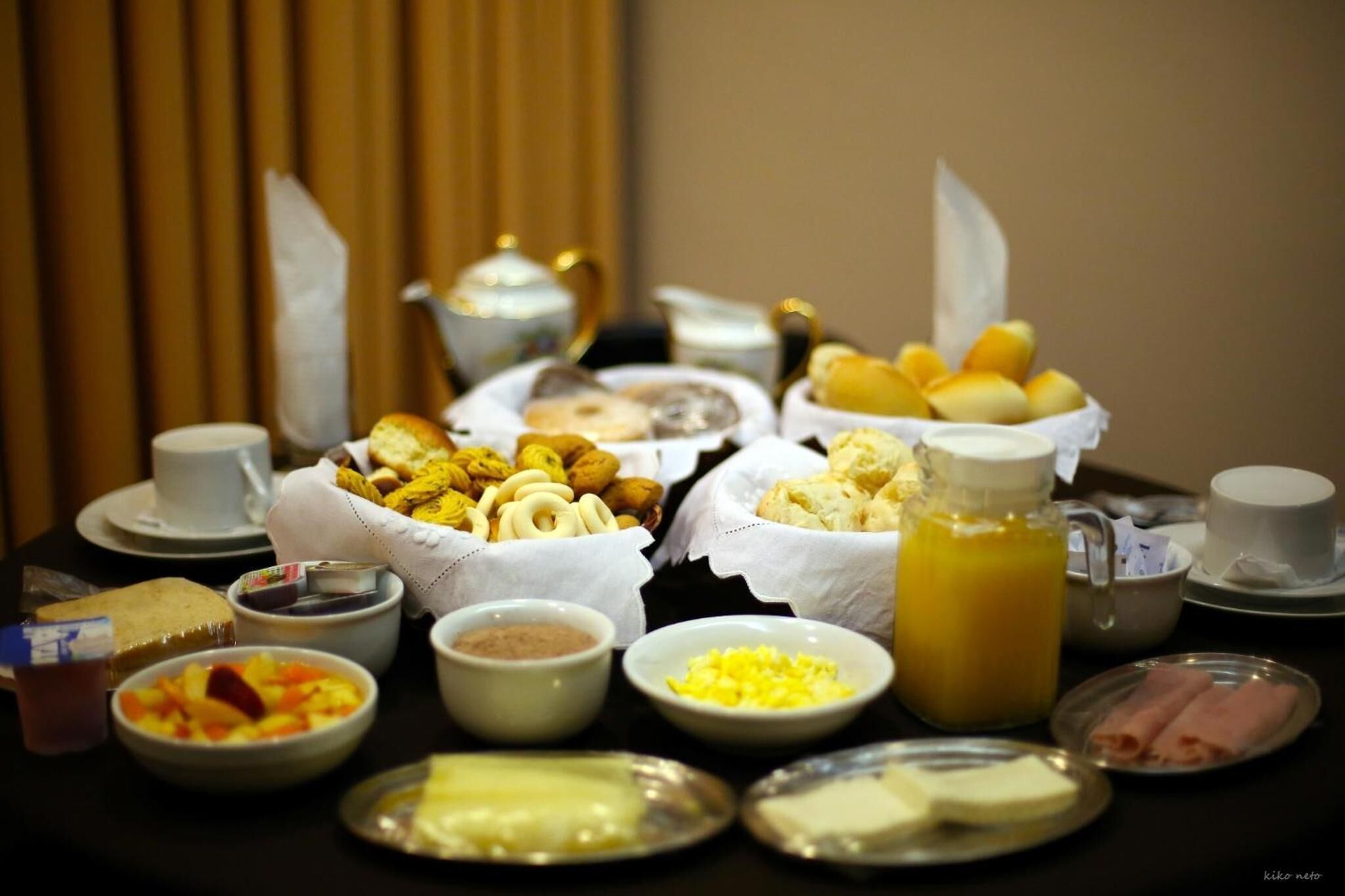 Um buffet de café da manhã com diversos alimentos e bebidas.