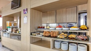 A buffet setup with various food items and beverages. - Pousada Costão dos Ingleses (Florianopolis)