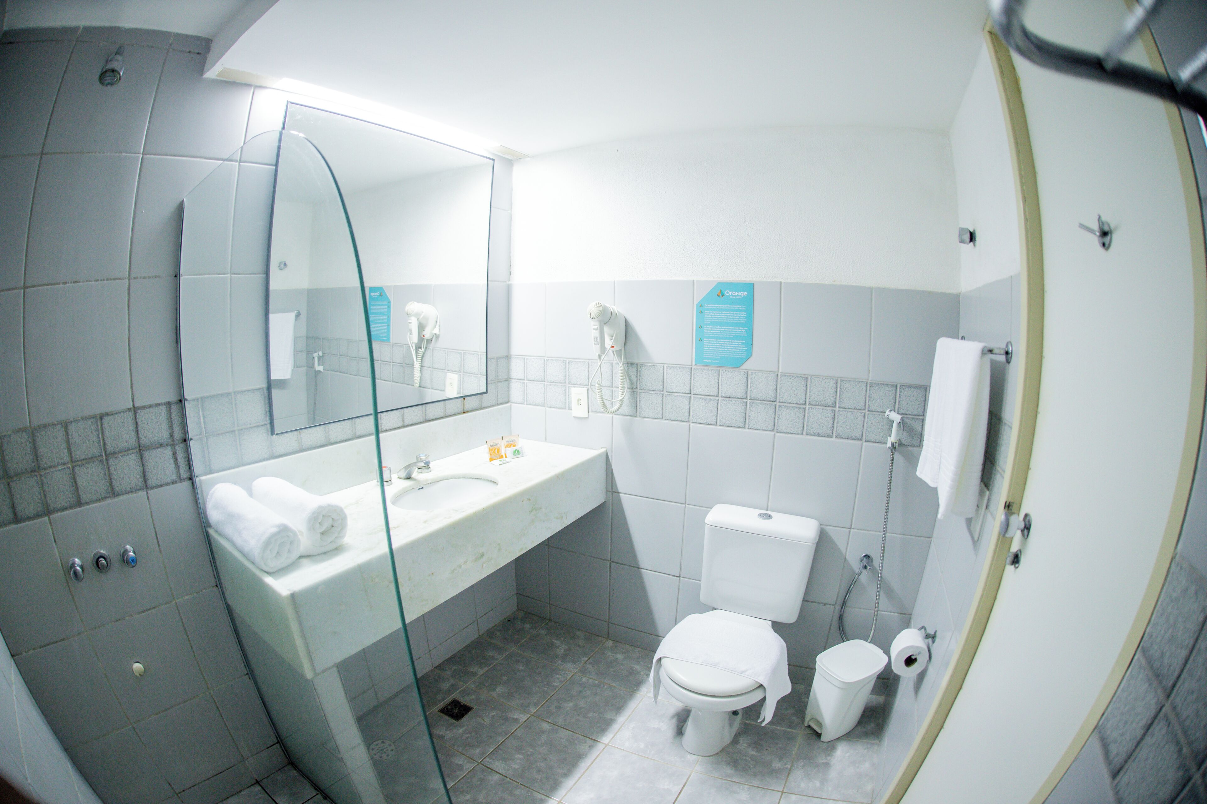 Un baño con cabina de ducha de vidrio, un lavamanos blanco con espejo, inodoro y bidé.