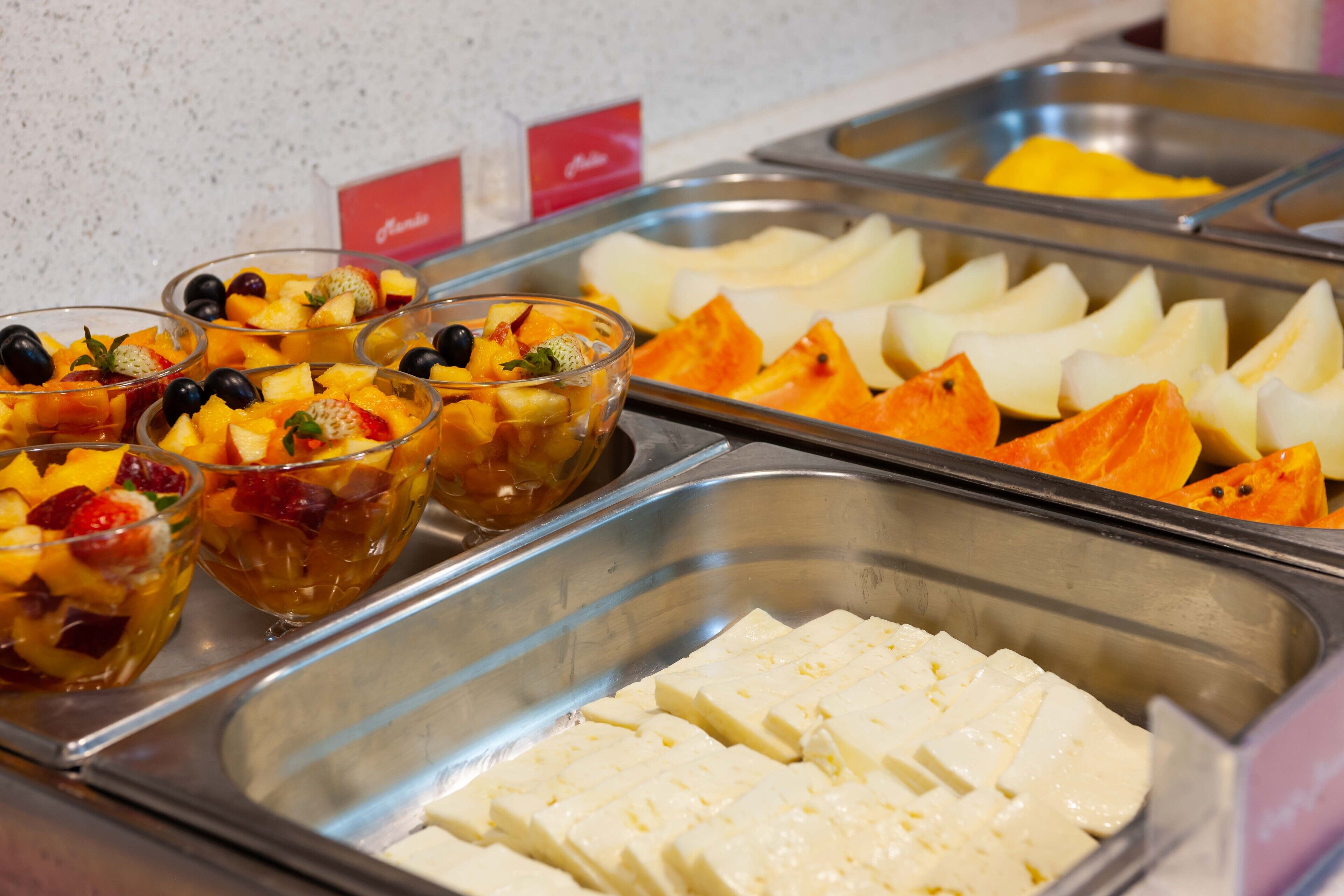 A buffet with various fruits and a cheese platter.