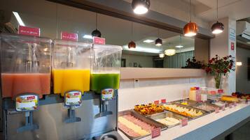 A buffet area with various food options and a juice dispenser.