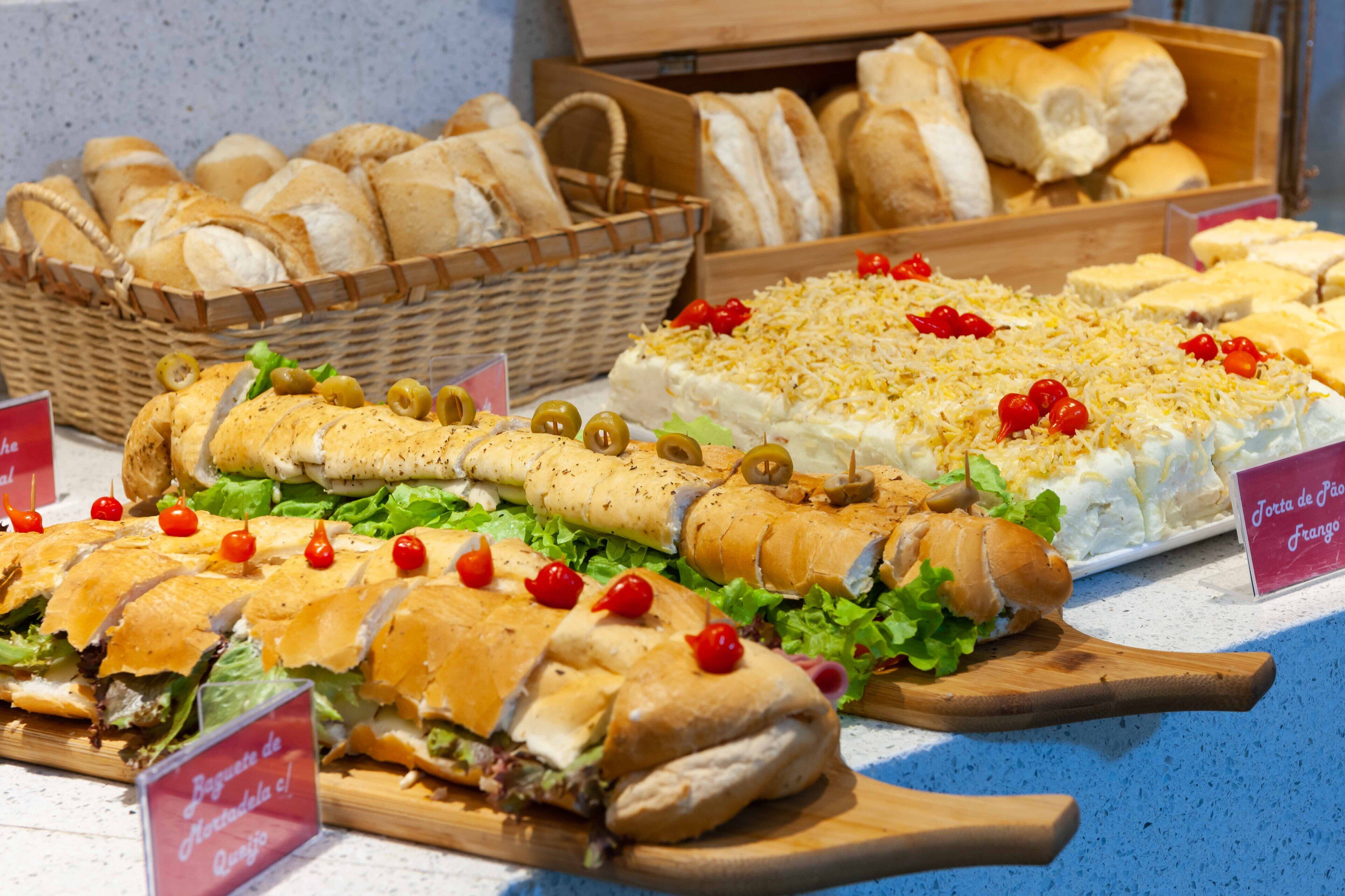 A variety of sandwiches and bread displayed on a counter.