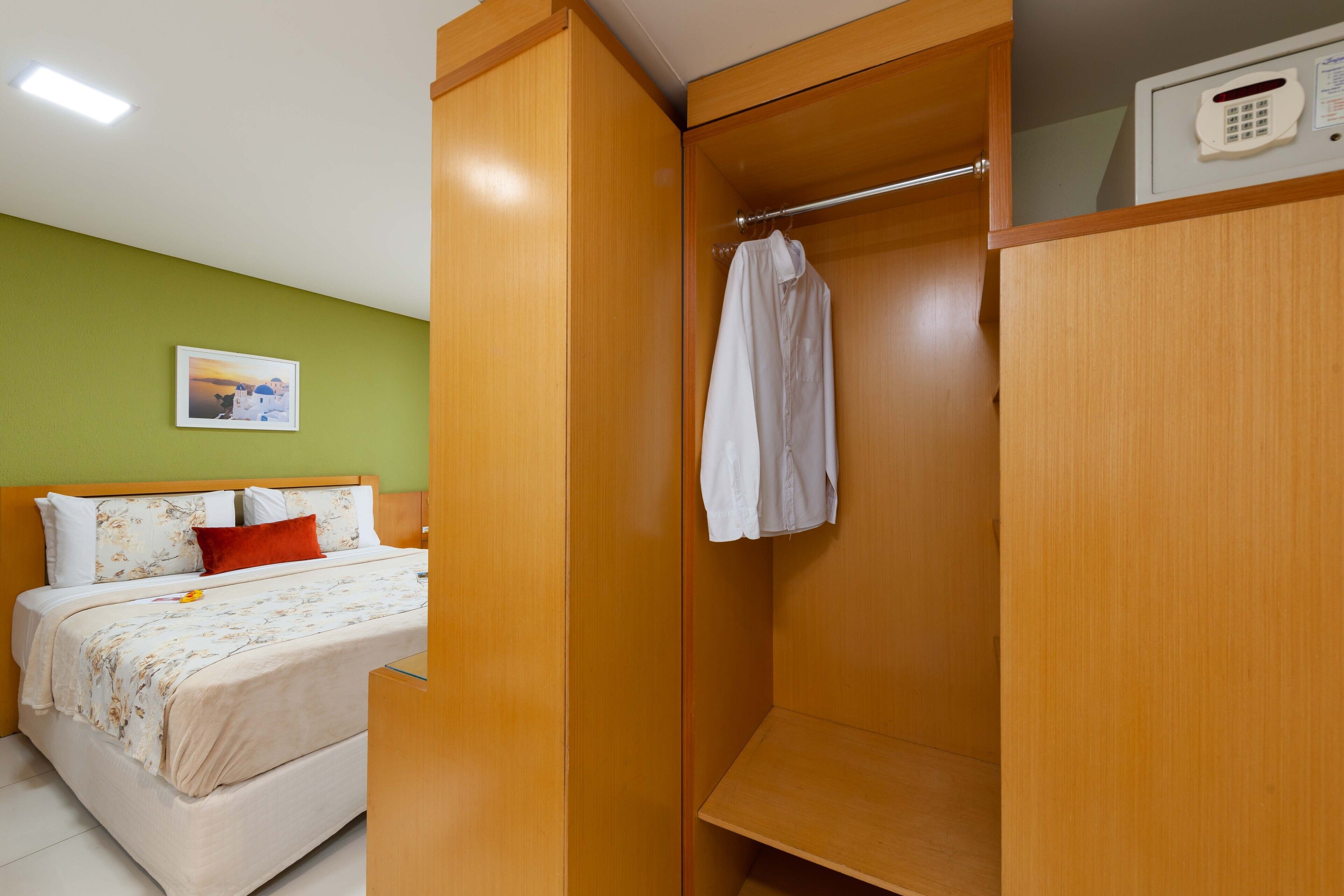 A bedroom with a bed, a wardrobe, and a bedside table.