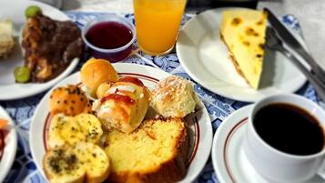 A breakfast table with various dishes including pancakes, a slice of pie, and a cup of coffee.