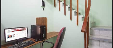 Un espacio de trabajo en casa con computadora, teclado y silla.