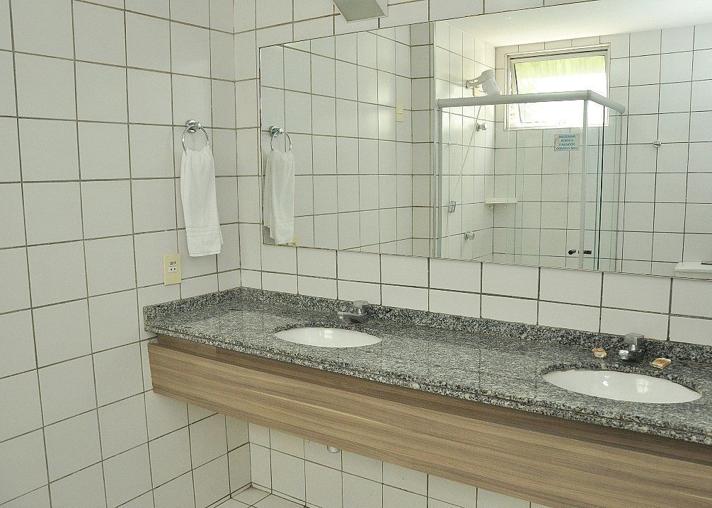 Un baño con dos lavamanos, un espejo y una ducha.