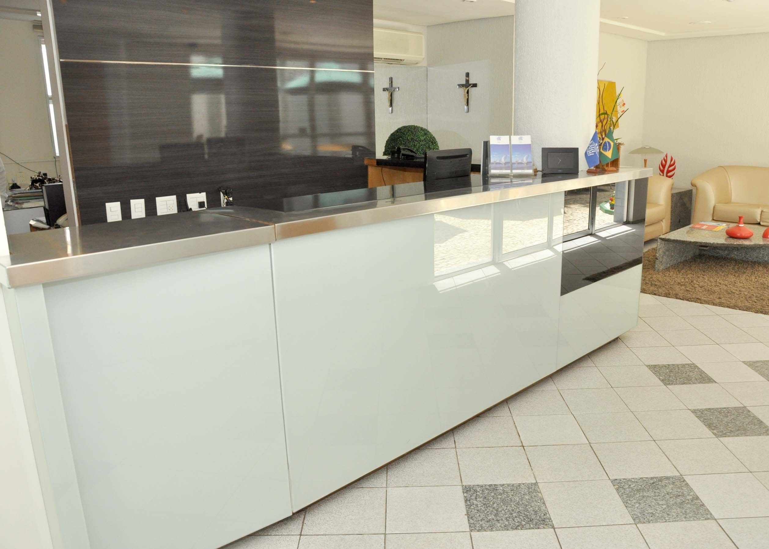 Una reception dal design moderno, una pianta e una croce appesa al muro.