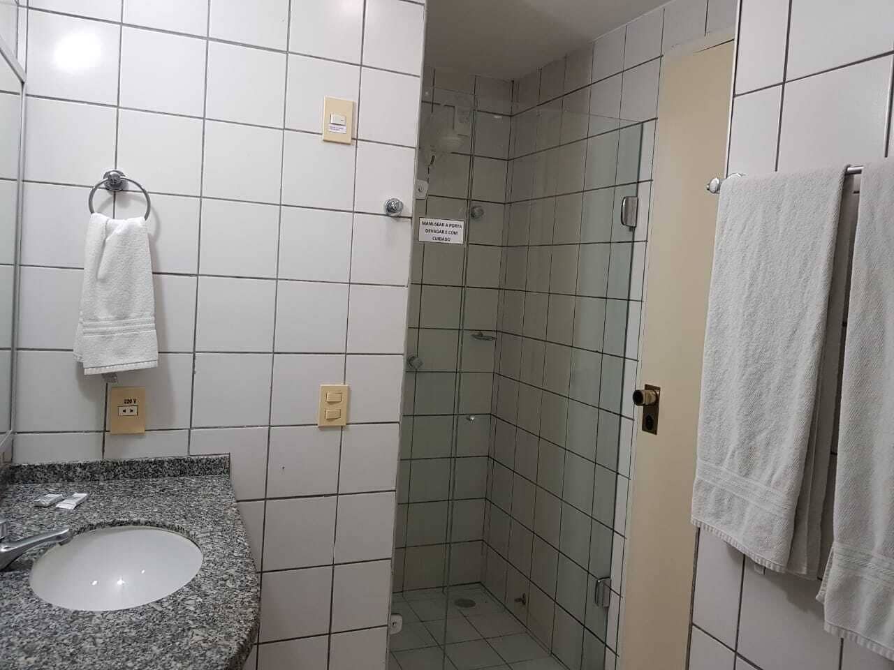 Un baño con lavabo, toallero y cabina de ducha.