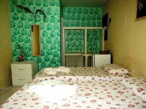 A small, compact bedroom with a bed, a dresser, and a mirror. - Farol do Forte Pousada (Fortaleza)