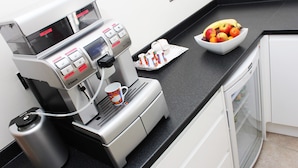 A coffee machine with a digital display, a water reservoir, and a mug holder. - Brentwood Hotel (Brentwood)