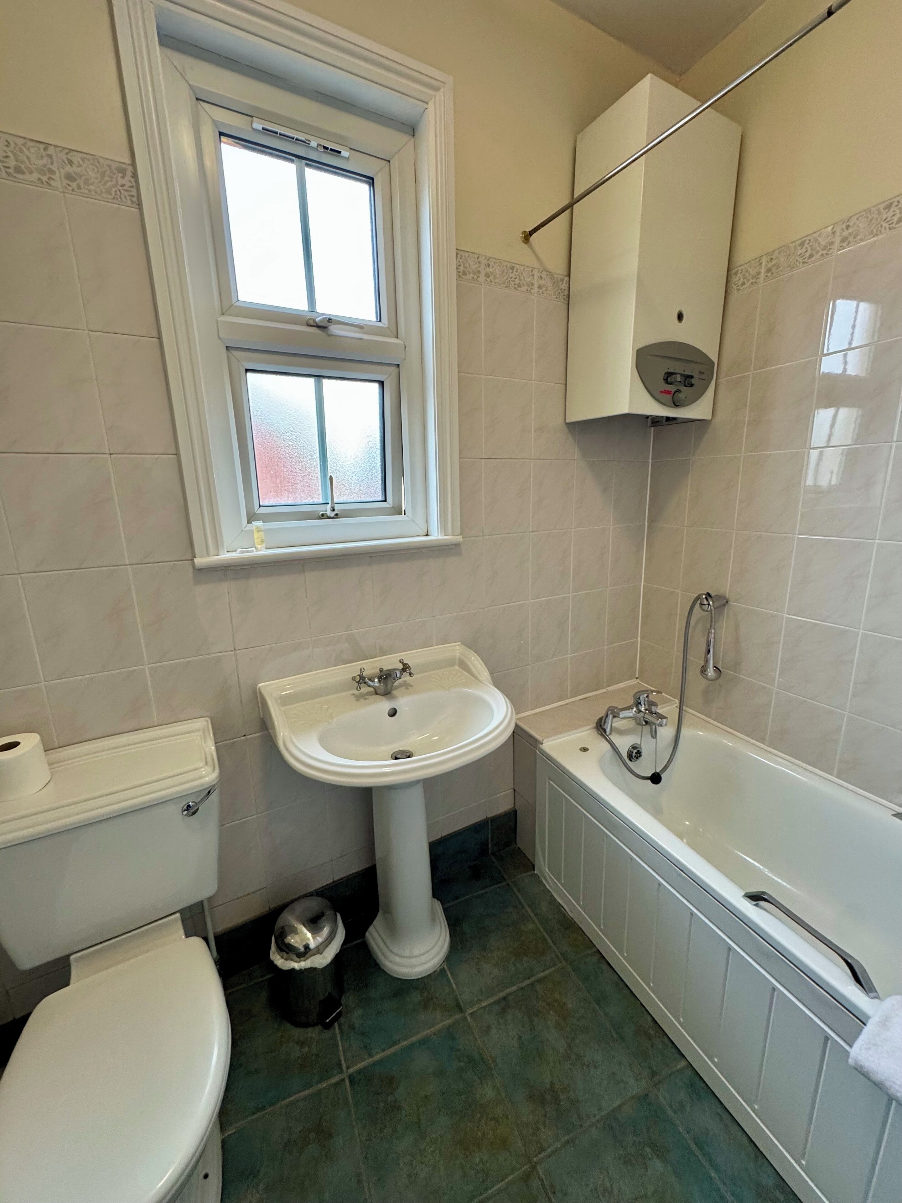 A bathroom with a toilet, sink, and bathtub.