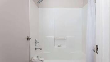 Ein Badezimmer mit Badewanne, Duschkopf und Handtuchhalter.