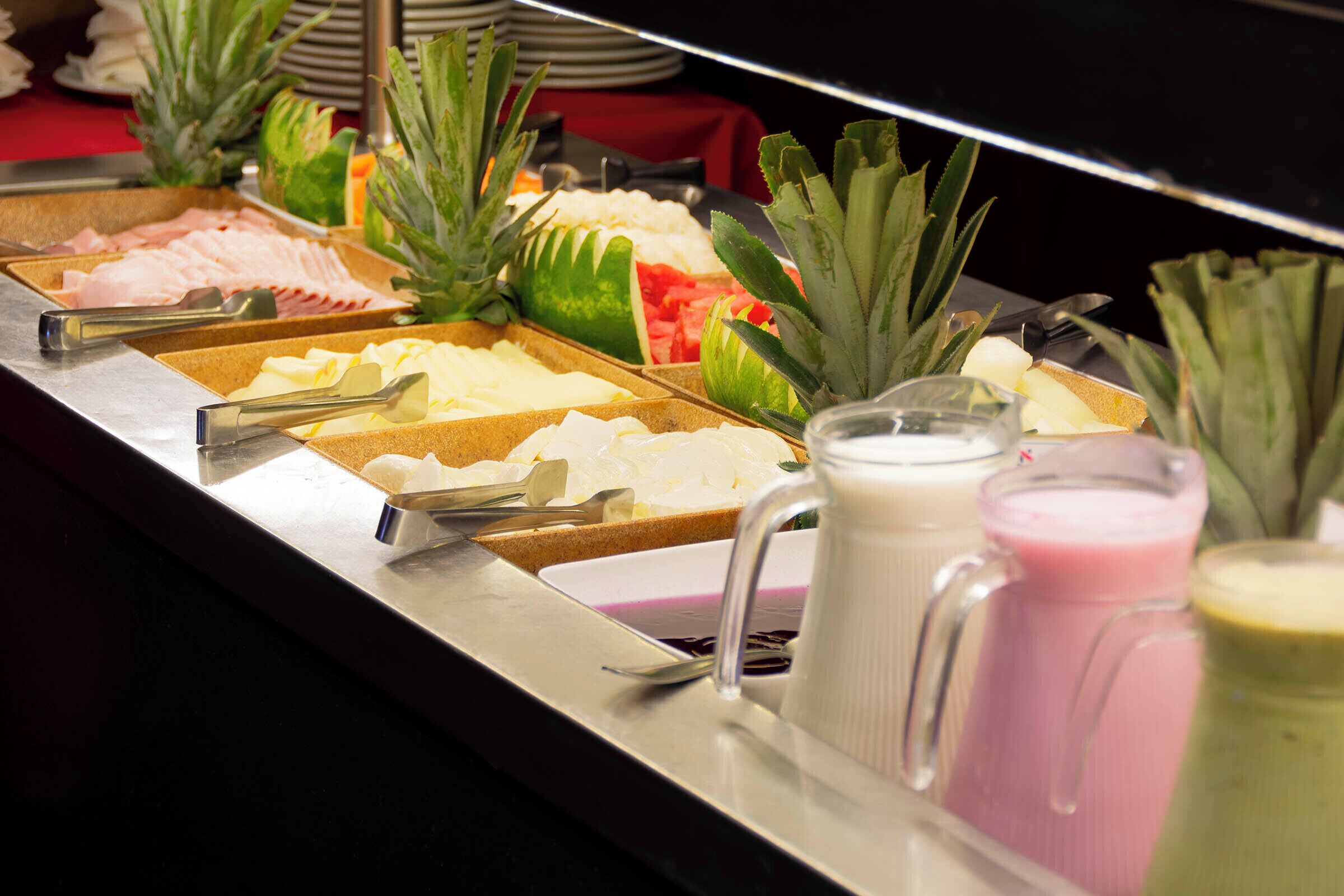 A buffet with various food items and drinks.