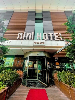 The exterior of the Mimi Hotel with a modern facade, a red carpet entrance, and a revolving door. - Mimi Hotel Ankara (Ankara)