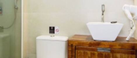 Un baño con inodoro, lavamanos, espejo y ducha.