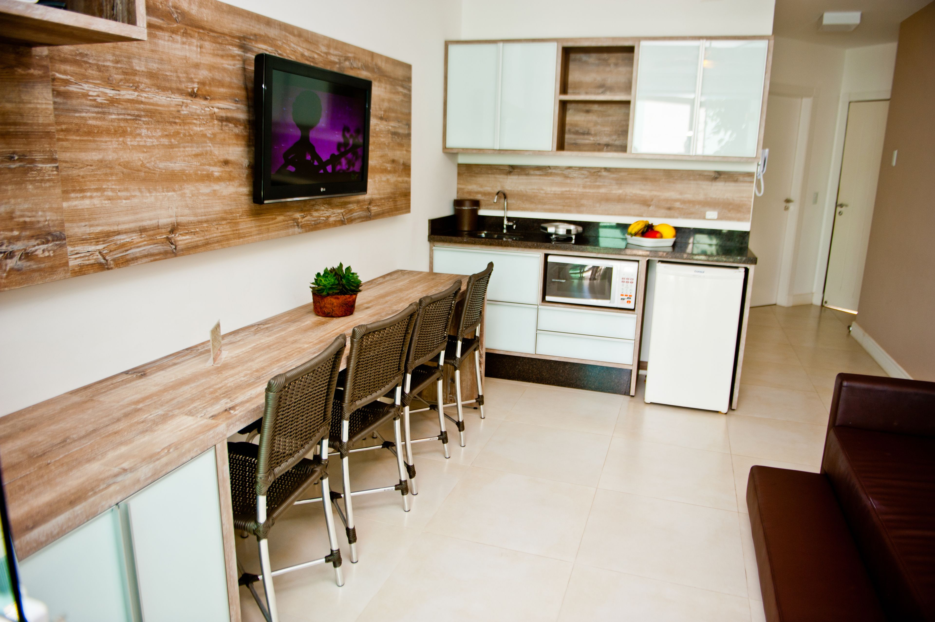 A modern kitchen with a wooden countertop, white cabinets, and a built-in oven.