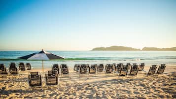 PĂ„ stranden, solstolar, parasoller och strandhanddukar