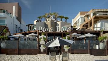 PĂ„ stranden, solstolar, parasoller och strandhanddukar