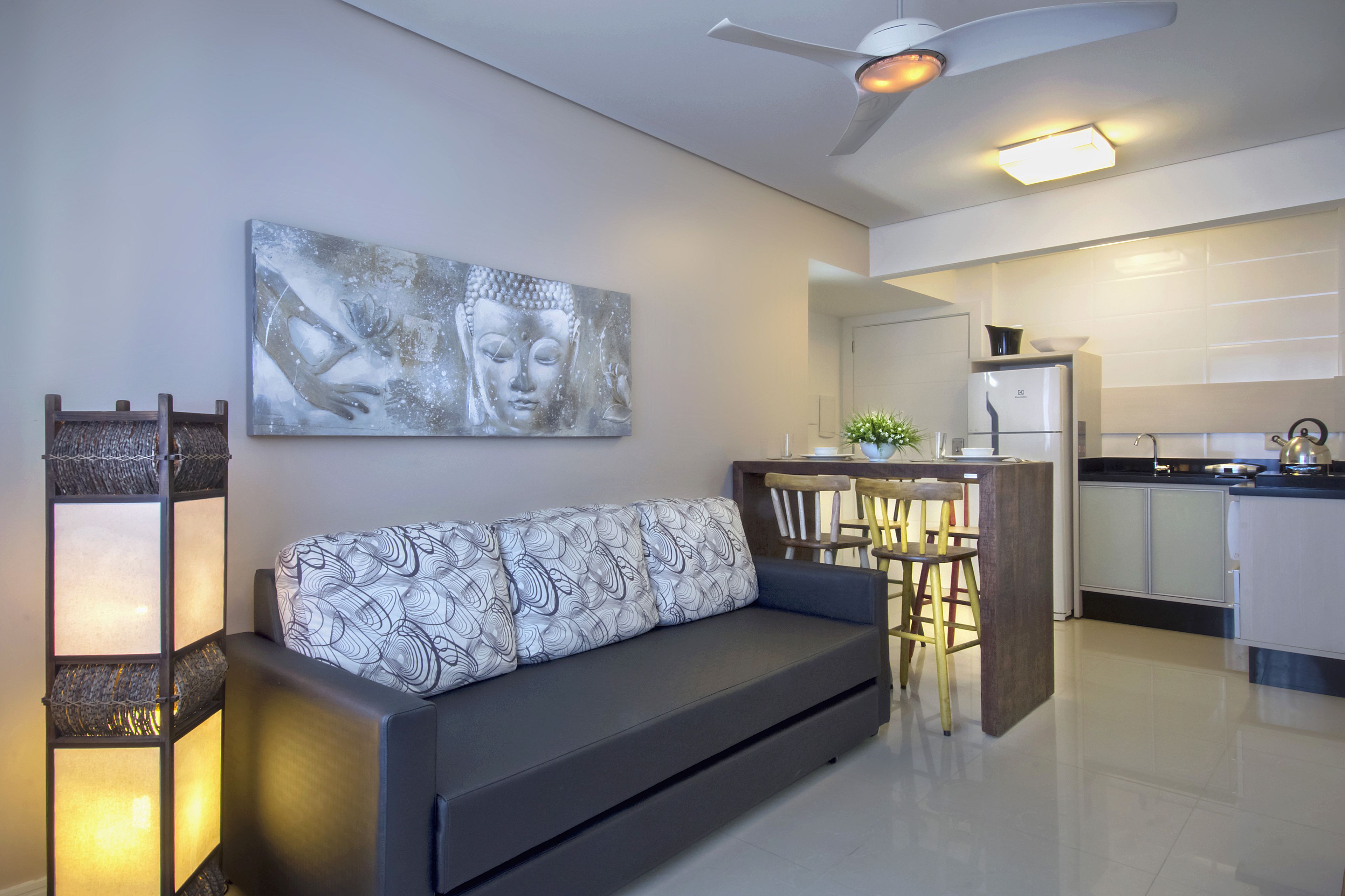 A modern living room with a sofa, a dining area, and a kitchen.