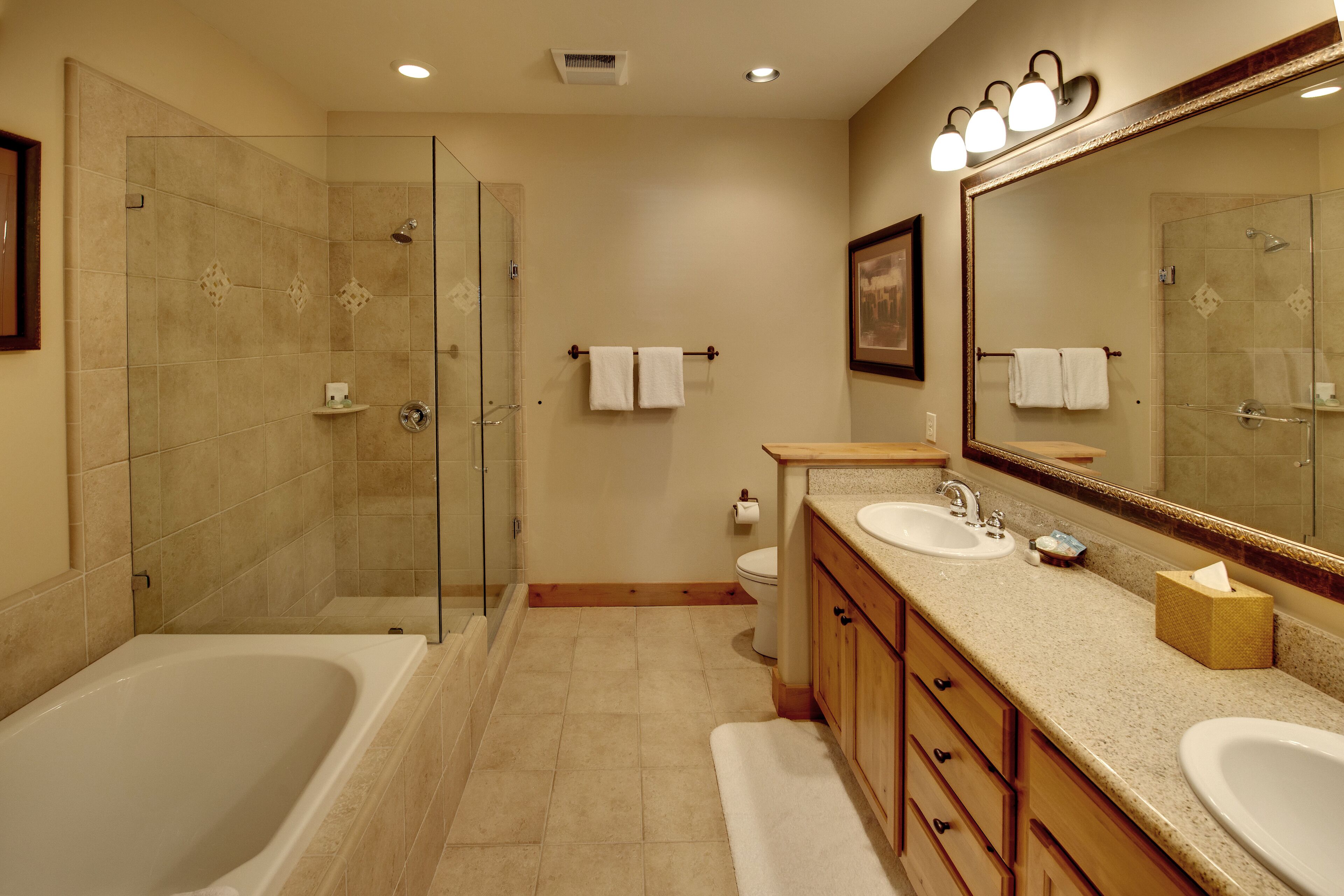 A modern bathroom with a glass-enclosed shower, a double sink vanity, and a large mirror.