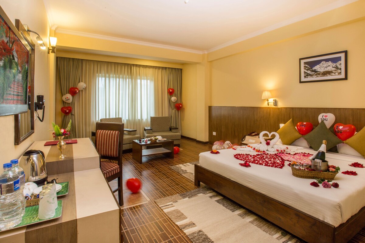 Une chambre d’hôtel comprenant un lit, un bureau, une chaise, un canapé et une table à manger.