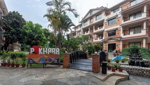 Una entrada con portón a un edificio residencial con un letrero que dice "PKHARA".
