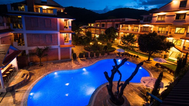 Una piscina rodeada de edificios de varios pisos con balcones y zonas de estar al aire libre.
