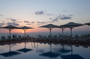 Una piscina al aire libre de temporada, sombrillas