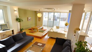 Uma sala de estar moderna com um sofá, uma mesa de centro e um pequeno espaço para refeições.