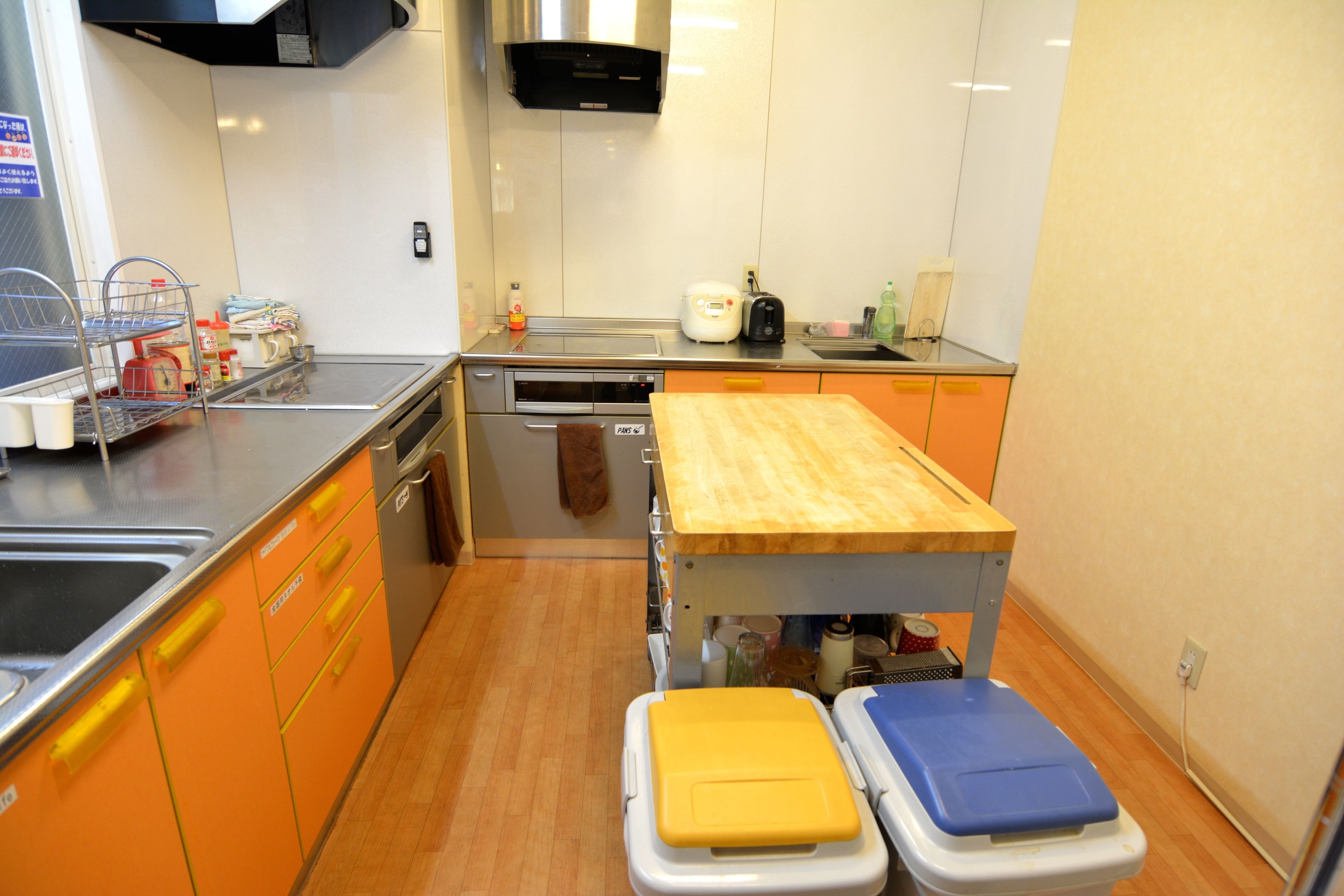 A compact kitchen with a sink, stove, and a wooden countertop.