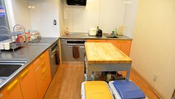 A compact kitchen with a sink, stove, and a wooden countertop.