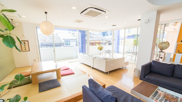 Uma sala de estar moderna com piso de tatame, um sofá, uma mesa de centro e vista para o exterior.