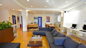 Uma sala de estar moderna com sofá seccional, mesa de centro e área de jantar com cadeiras e mesa.