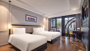 Quarto de hotel com duas camas, uma janela grande com vista e uma escada.