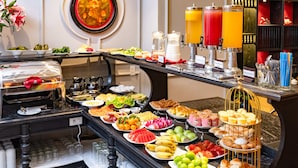 Buffet com diversos alimentos, incluindo frutas, doces e bebidas.
