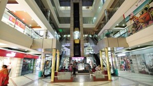 A multi-level shopping mall with escalators, glass railings, and various stores. - Hotel Grand Mumtaz Towers (Srinagar)