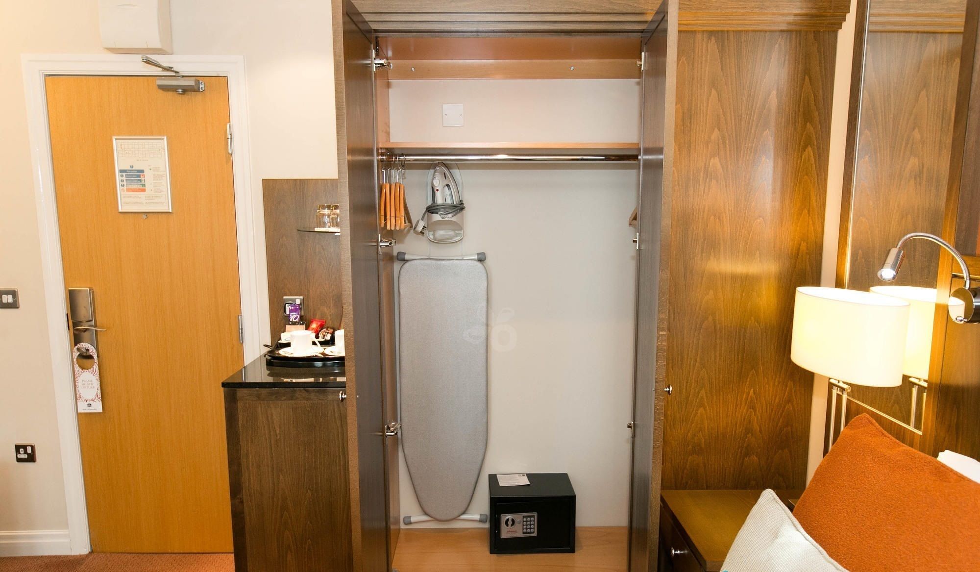 A compact bathroom with a shower, a small vanity with a mirror, and a towel rack.