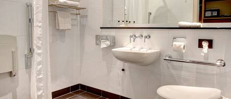 A modern bathroom with a shower, toilet, sink, and a towel rack.