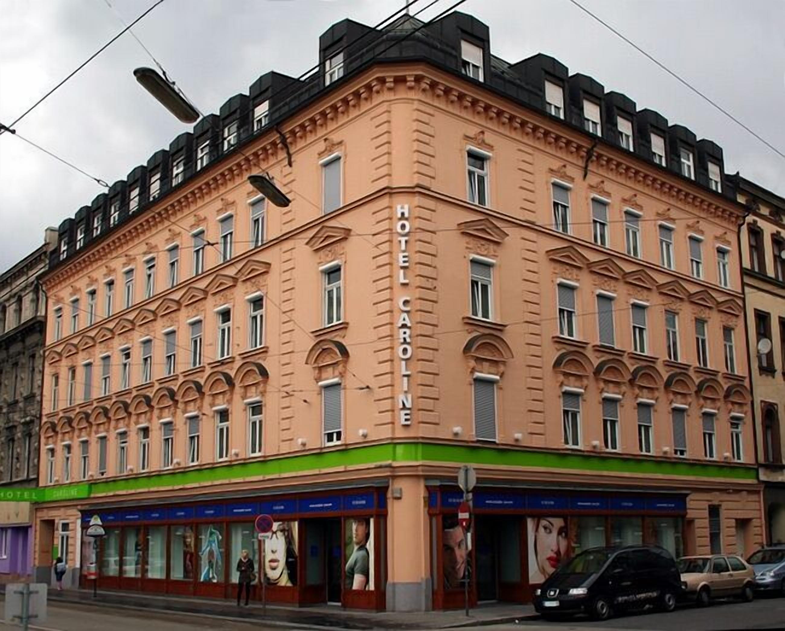 A multi-story hotel with a classic architectural style, featuring a prominent entrance with a green awning and multiple windows.